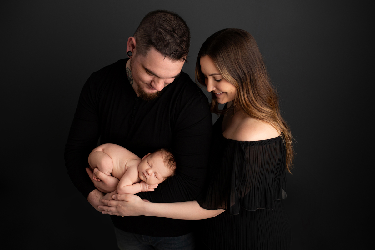 Parents pose with new baby girl wearing black