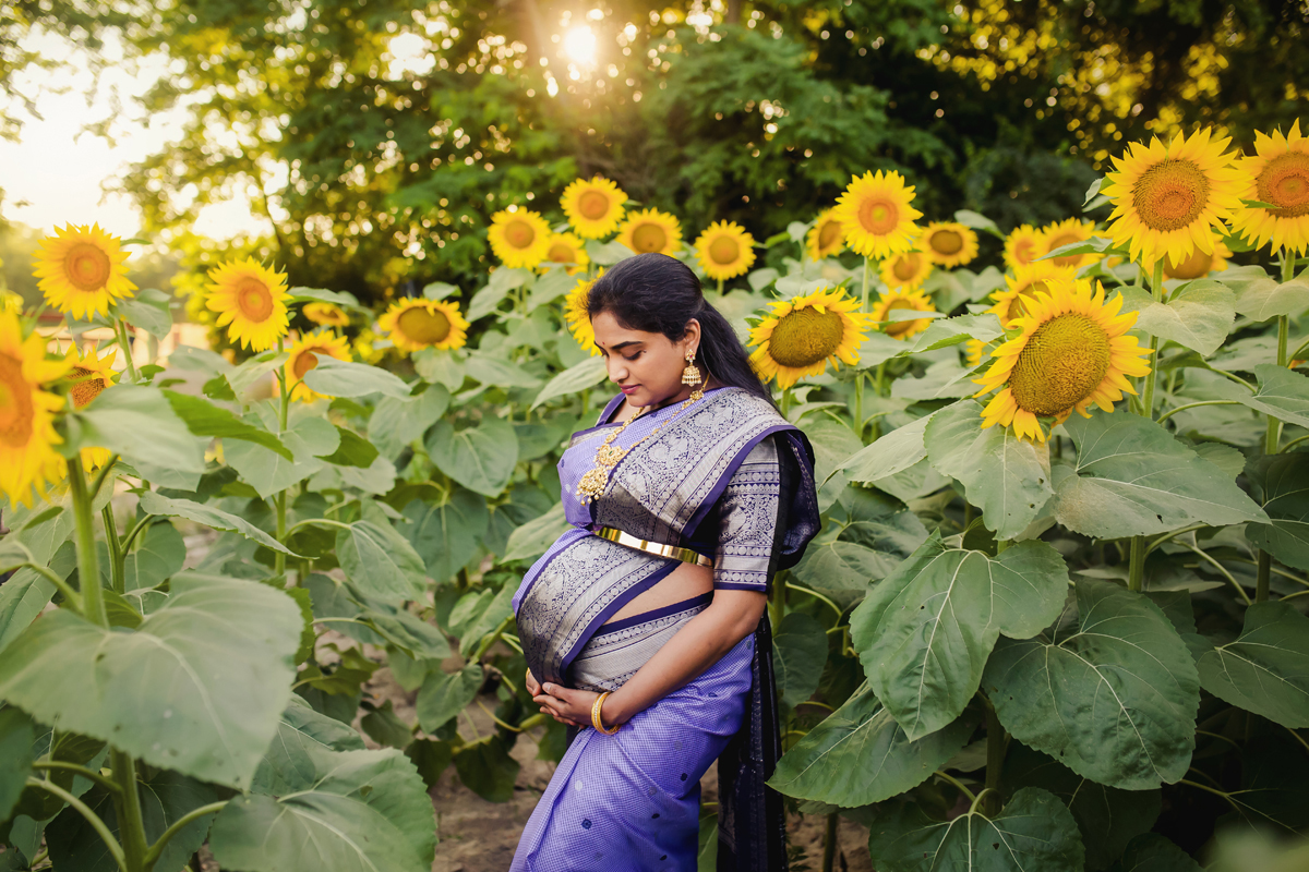 Indian women wears traditional outfit in a field of sunflowers
